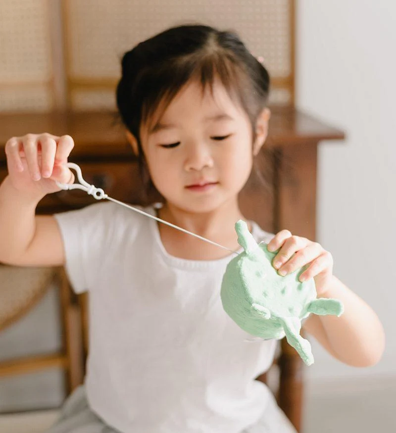Child playing calmly with a soft sensory plush toy